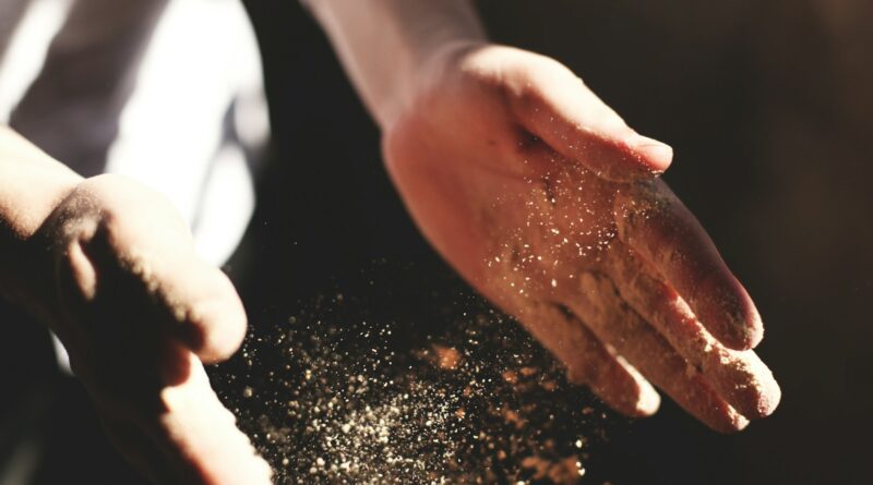 person's hand with dust during daytime